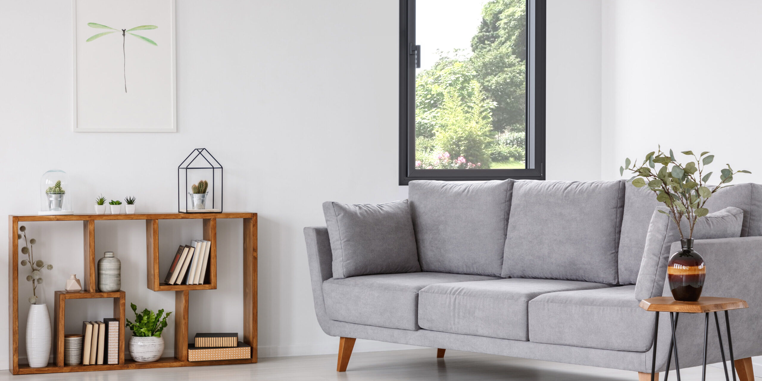 Plant on wooden table next to grey sofa in natural living room interior with poster. Real photo Dimension d'une fenêtre standard