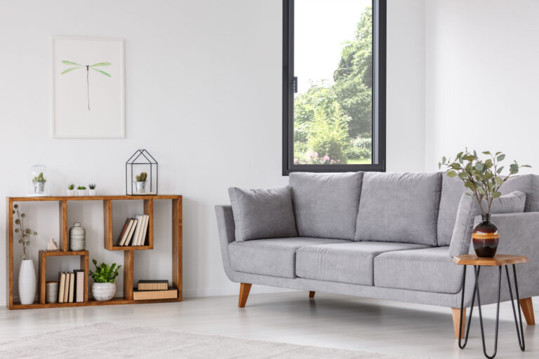 Plant on wooden table next to grey sofa in natural living room interior with poster. Real photo Dimension d'une fenêtre standard